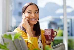 Happy woman on phone with coffee mug
