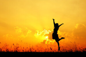 woman jumping at sunset