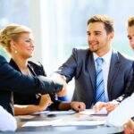 business people shaking hands across a table